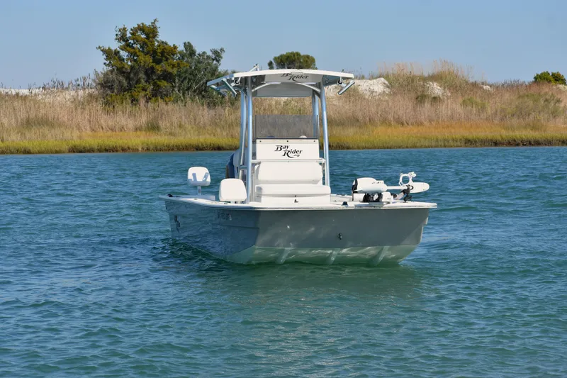 Slide: The Image of 2017 Bay Rider 2260 FS Skiff on calm water, surrounded by natural scenery. - 3
