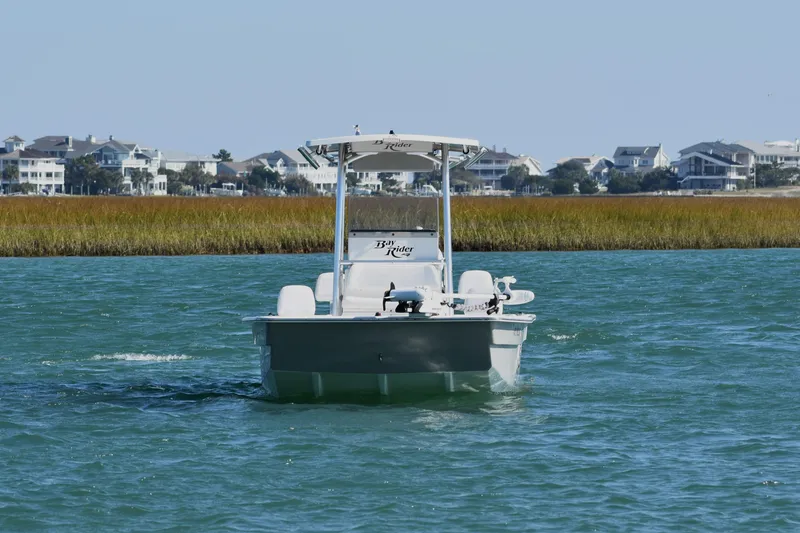 Slide: The Image of 2017 Bay Rider 2260 FS Skiff on water near coastal homes. - 4