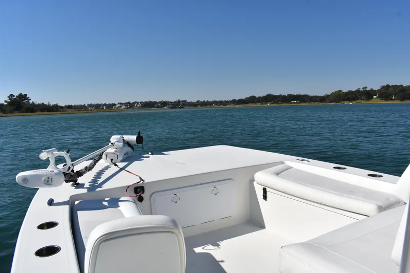 Slide: The Image of 2017 Bay Rider 2260 FS Skiff on calm water, featuring a spacious deck and seating. - 5