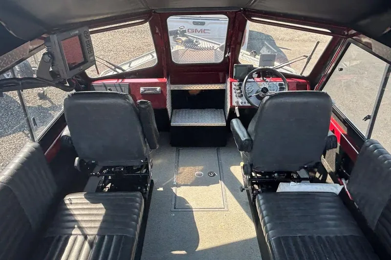 Slide: The Image of Interior of a 2005 THINDERJET 21 ALEXIS boat with black seating and steering controls. - 5