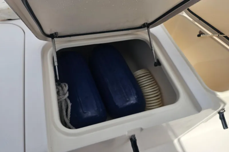 Slide: The Image of Open storage compartment on 2003 Grady-White Bimini 306 boat with fenders and rope. - 17