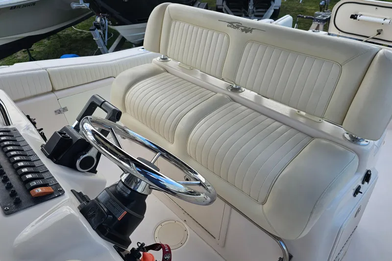 Slide: The Image of 2003 Grady-White Bimini 306 boat interior with steering wheel and cushioned seating. - 23