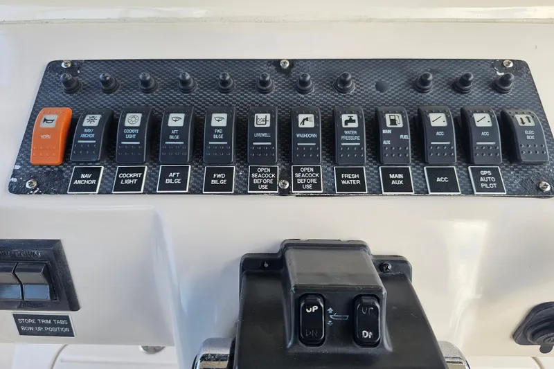 Slide: The Image of Control panel of a 2003 Grady-White Bimini 306 boat with labeled switches. - 28