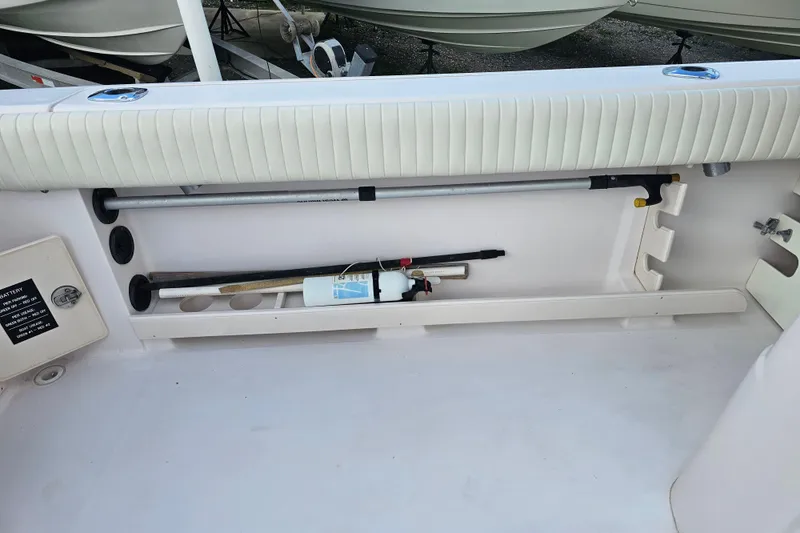 Slide: The Image of Storage compartment on a 2003 Grady-White Bimini 306 boat, featuring safety equipment. - 36