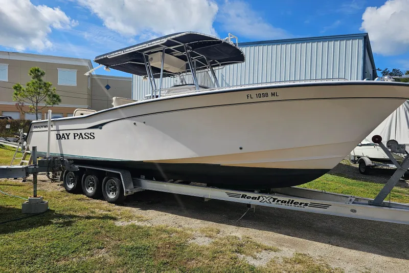 Slide: The Image of 2003 Grady-White Bimini 306 boat on trailer, labeled "Day Pass," parked outdoors. - 5
