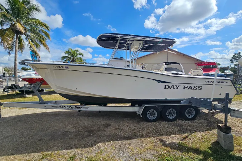 Slide: The Image of 2003 Grady-White Bimini 306 boat on trailer, sunny day, palm trees in background. - 8