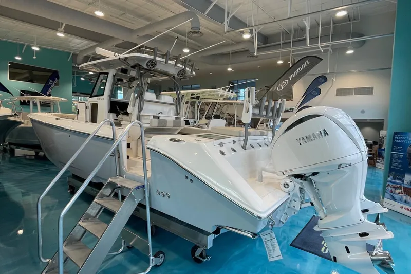 Slide: The Image of 2025 Solace 32 CS boat with Yamaha engine displayed in a showroom. - 0
