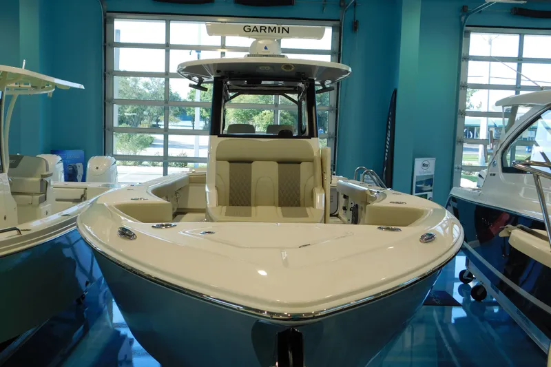 Slide: The Image of 2025 Solace 32 CS boat in showroom, featuring Garmin equipment and sleek design. - 1