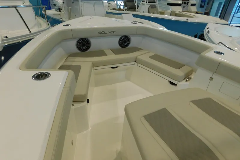 Slide: The Image of 2025 Solace 32 CS boat interior with cushioned seating and built-in speakers. - 11