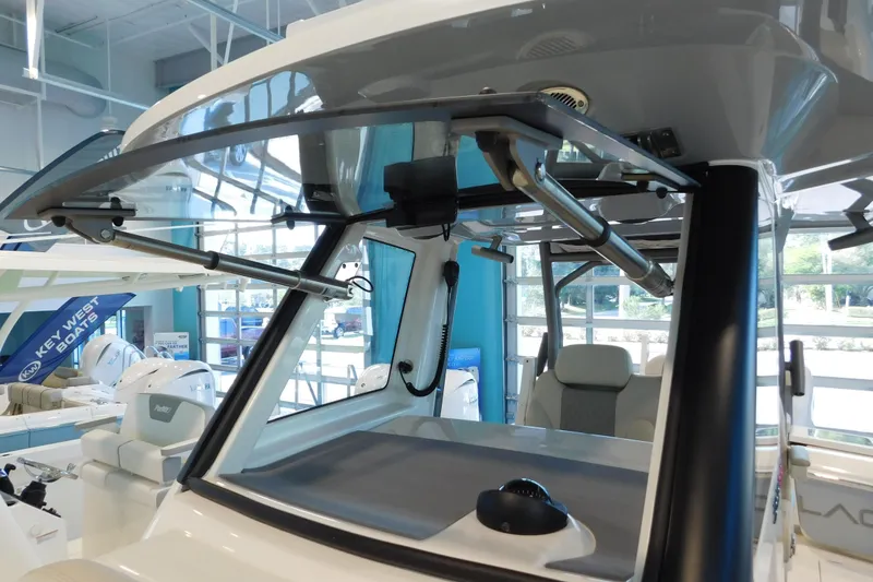 Slide: The Image of 2025 Solace 32 CS boat interior showcasing helm and seating area in showroom. - 12