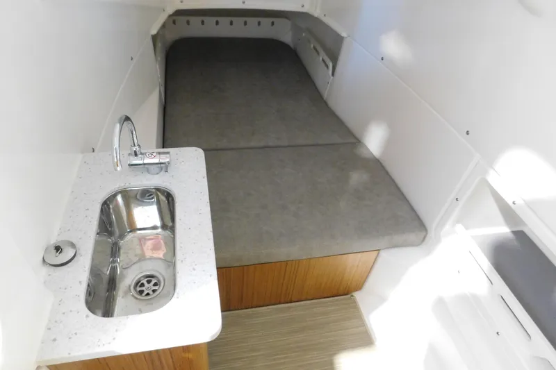 Slide: The Image of 2025 Solace 32 CS cabin interior with compact sink and cozy bed. - 14