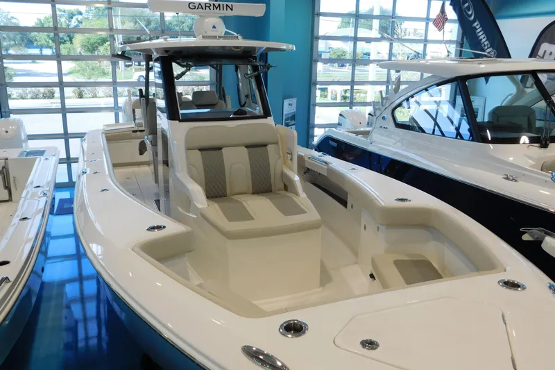 Slide: The Image of 2025 Solace 32 CS boat in showroom, featuring sleek design and advanced Garmin navigation system. - 2