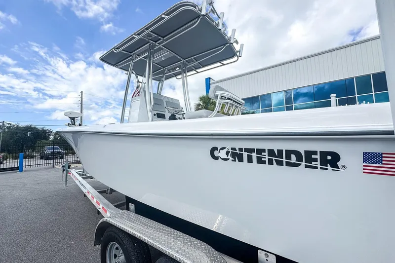 Slide: The Image of 2025 Contender 25 Tournament boat on trailer, displayed outdoors near a modern building. - 12