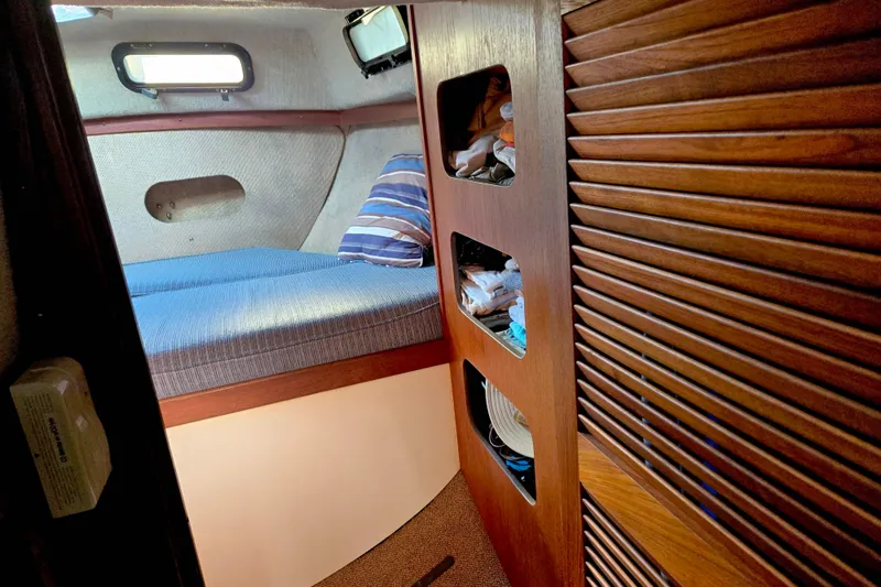 Slide: The Image of 1985 S2 Yachts 9.2 C cabin interior with bed and wooden storage shelves. - 16