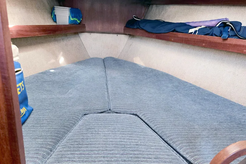 Slide: The Image of Interior cabin of 1985 S2 Yachts 9.2 C sailboat with blue cushions and wooden shelves. - 17