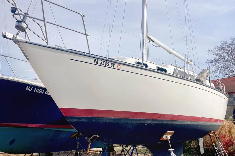 Slide: The Image of 1985 S2 Yachts 9.2 C sailboat on dry dock, white hull with red stripe. - 4