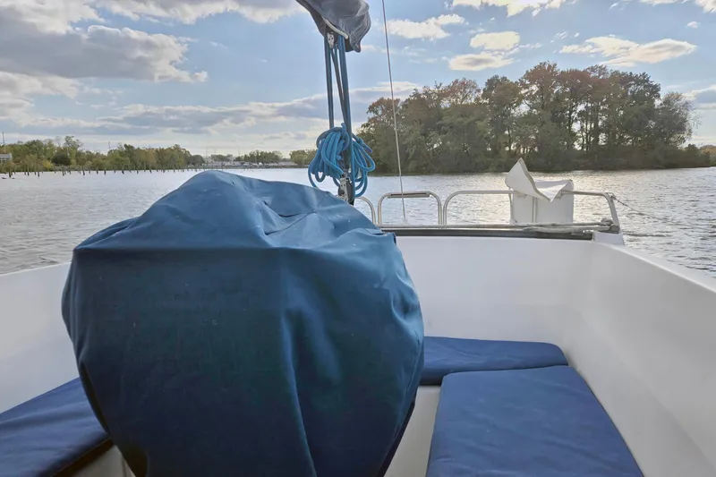 Slide: The Image of 1985 S2 Yachts 9.2 C sailboat cockpit with blue cover, scenic water view. - 9