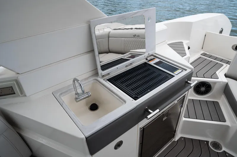 Slide: The Image of Luxury outdoor kitchen on 2022 Sea Ray SLX 350 Outboard boat, featuring sink and grill. - 16