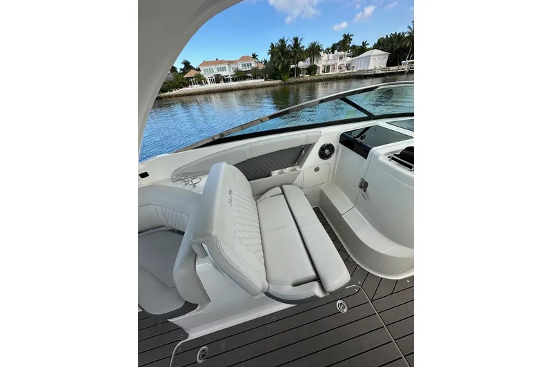 Slide: The Image of 2022 Sea Ray SLX 350 Outboard interior with luxurious seating and waterfront view. - 7