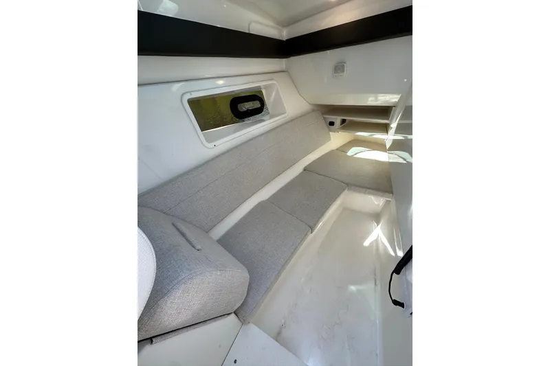 Slide: The Image of 2022 Sea Ray SLX 350 Outboard cabin interior with gray seating and window. - 8