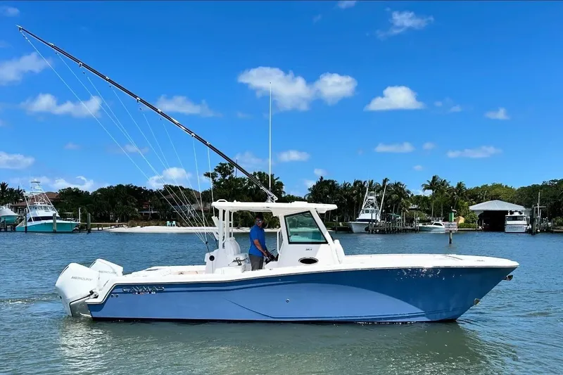 The Image of 2024 Caymas 30 CT boat on water, clear sky, fishing rods, tropical background. - 0