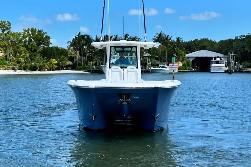 Slide: The Image of 2024 Caymas 30 CT boat on calm water, surrounded by tropical scenery. - 1