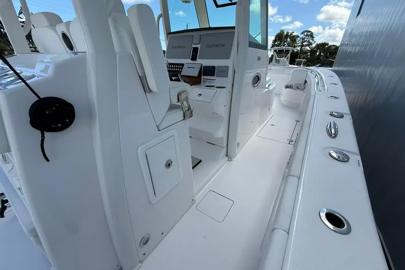 Slide: The Image of 2024 Caymas 30 CT boat interior with modern controls and seating under a blue sky. - 12