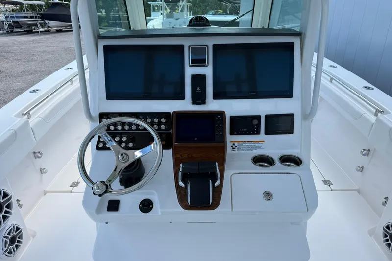 Slide: The Image of 2024 Caymas 30 CT boat dashboard with steering wheel, dual screens, and control panel. - 15