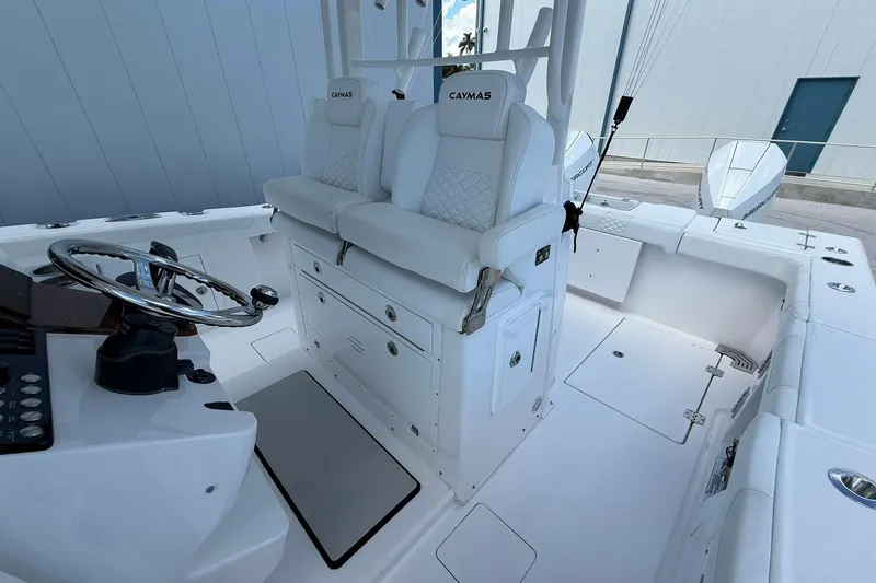 Slide: The Image of 2024 Caymas 30 CT boat interior with dual seats, steering wheel, and control panel. - 16