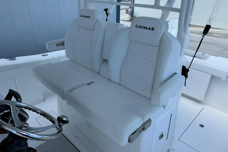 Slide: The Image of 2024 Caymas 30 CT boat interior with white cushioned seating and steering wheel. - 18