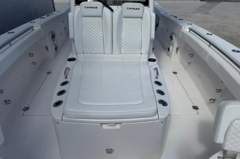 Slide: The Image of 2024 Caymas 30 CT boat interior with white cushioned seating and cup holders. - 25