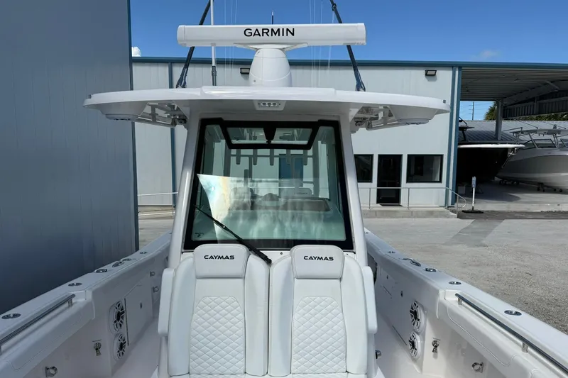 Slide: The Image of 2024 Caymas 30 CT boat with Garmin equipment, docked near a modern building. - 26