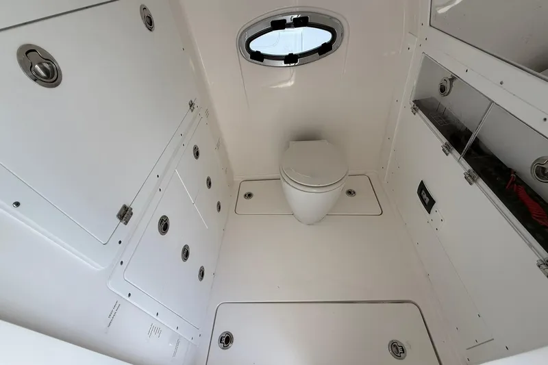 Slide: The Image of 2024 Caymas 30 CT boat interior with white marine toilet and storage compartments. - 27