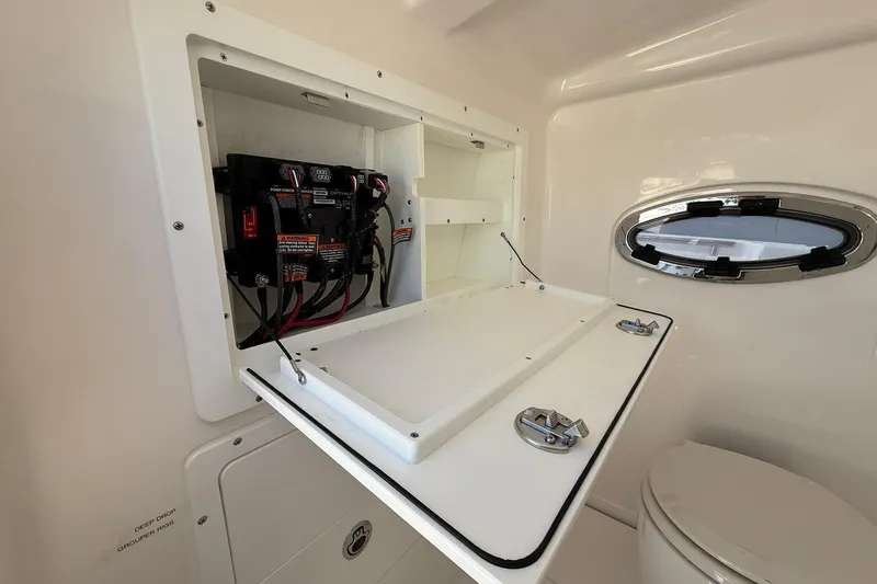 Slide: The Image of 2024 Caymas 30 CT boat interior with electrical panel and porthole window. - 28