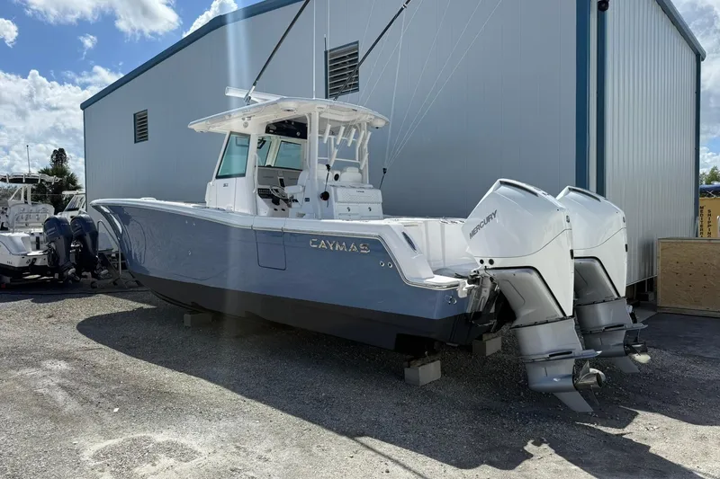 Slide: The Image of 2024 Caymas 30 CT boat with dual Mercury outboard engines, parked outdoors. - 3