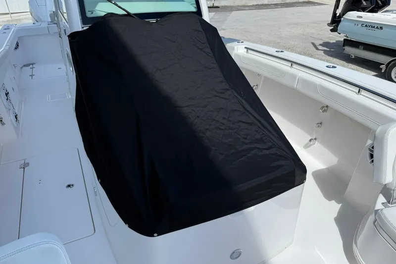 Slide: The Image of 2024 Caymas 30 CT boat interior with black cover, showcasing sleek white seating and deck. - 30
