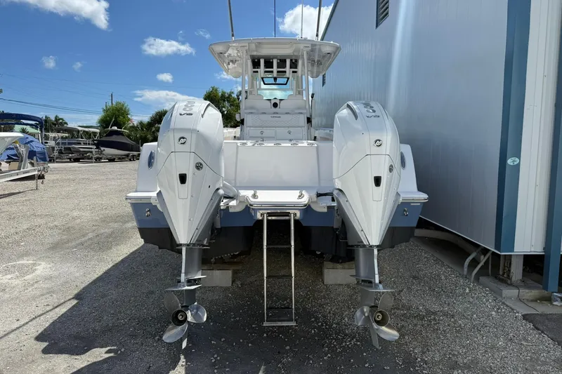 Slide: The Image of 2024 Caymas 30 CT boat with dual outboard engines, parked outdoors. - 4