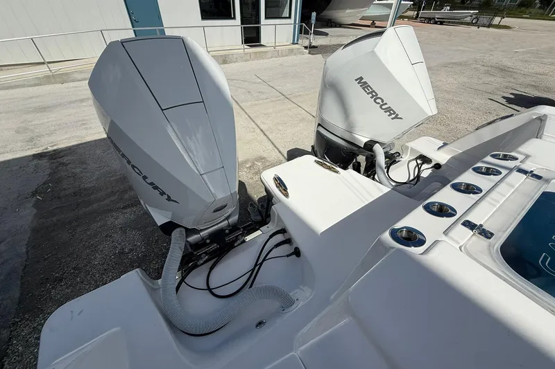 Slide: The Image of 2024 Caymas 30 CT boat with dual Mercury outboard engines, docked outdoors. - 5