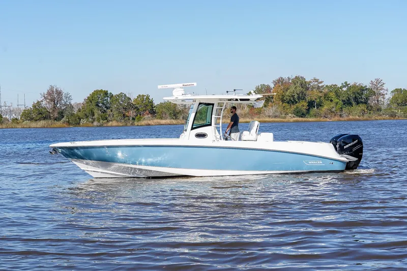 The Image of 2013 Boston Whaler 320 Outrage boat cruising on a calm river. - 1
