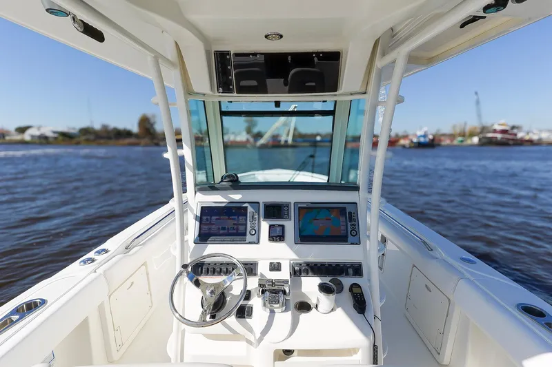 Slide: The Image of 2013 Boston Whaler 320 Outrage boat cockpit with navigation equipment on a sunny day. - 16
