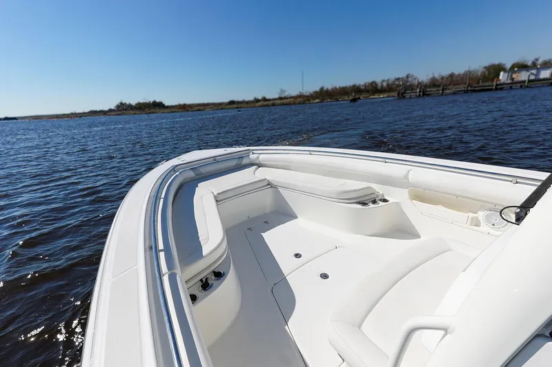 Slide: The Image of 2013 Boston Whaler 320 Outrage boat on calm water, showcasing spacious deck and seating. - 21