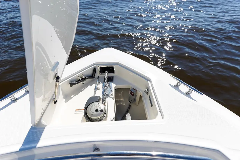 Slide: The Image of 2013 Boston Whaler 320 Outrage anchor compartment with open hatch, on calm water. - 24