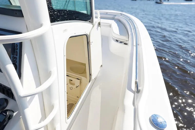 Slide: The Image of 2013 Boston Whaler 320 Outrage boat interior with open cabin door, on water. - 26