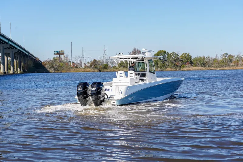 Slide: The Image of 2013 Boston Whaler 320 Outrage boat cruising on a river near a bridge. - 4