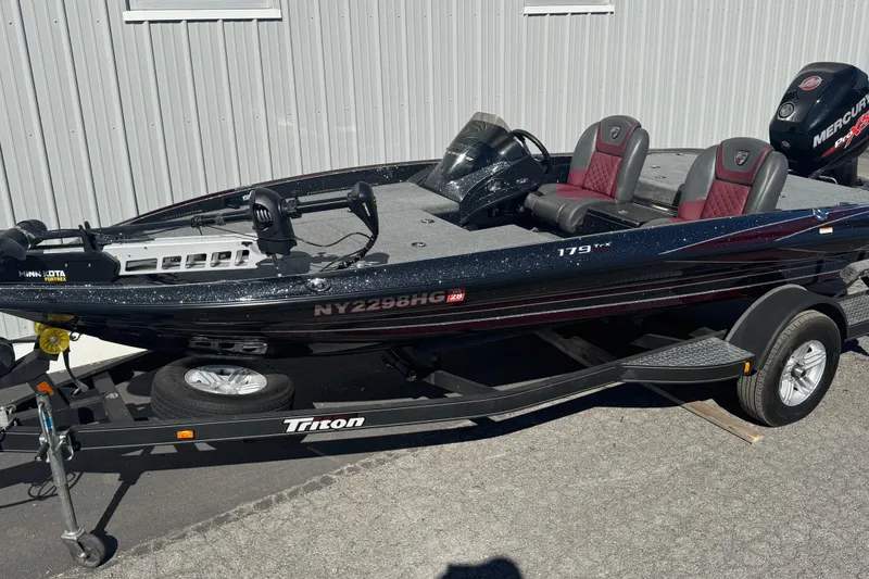 Slide: The Image of 2016 Triton 179 TrX fishing boat on trailer, featuring Minn Kota trolling motor. - 0