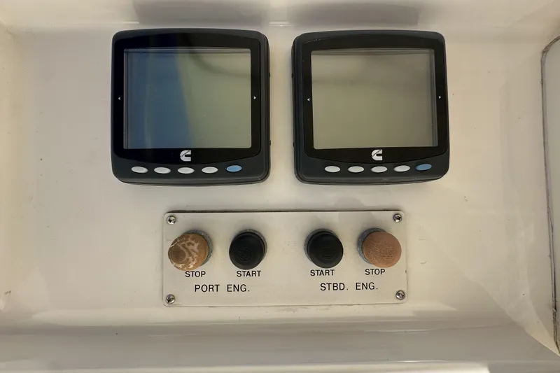 Slide: The Image of Control panel of a 2004 McKinna 57 PHMY Widebody yacht with dual screens and engine buttons. - 101