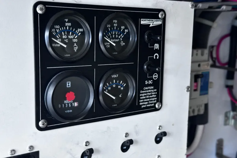 Slide: The Image of Control panel of a 2004 McKinna 57 PHMY Widebody yacht, displaying gauges and switches. - 103