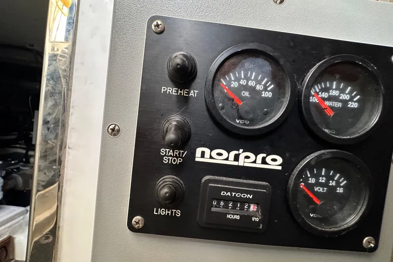 Slide: The Image of Control panel of a 2004 McKinna 57 PHMY Widebody yacht, featuring gauges and switches. - 104