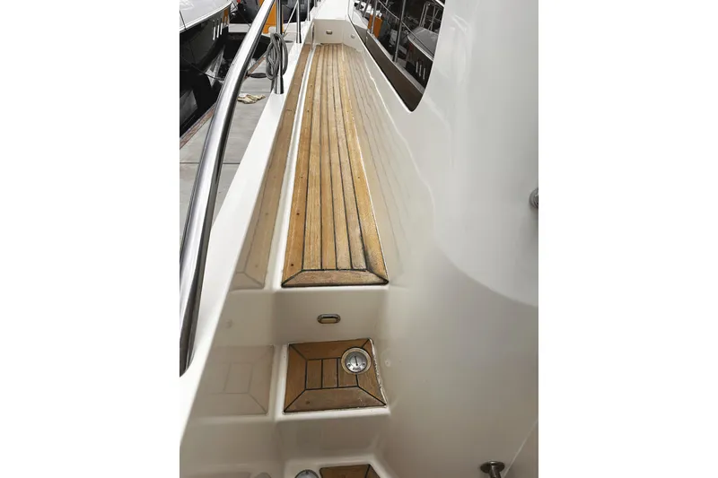 Slide: The Image of 2004 McKinna 57 PHMY yacht deck with wooden flooring and railing. - 17