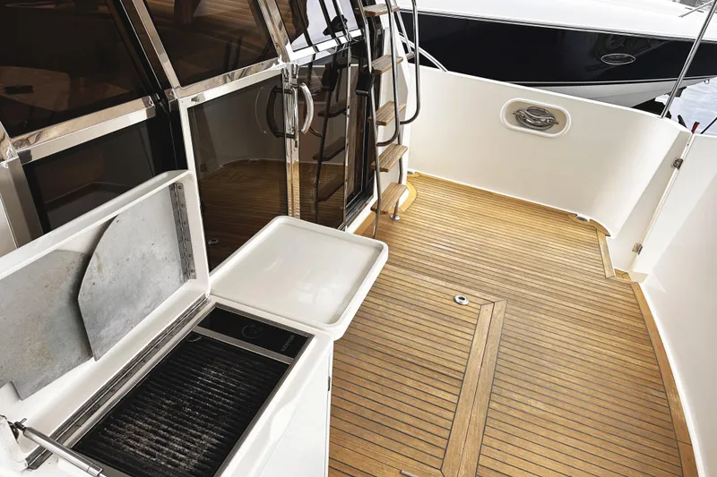 Slide: The Image of 2004 McKinna 57 PHMY yacht deck with wood flooring and outdoor grill. - 23